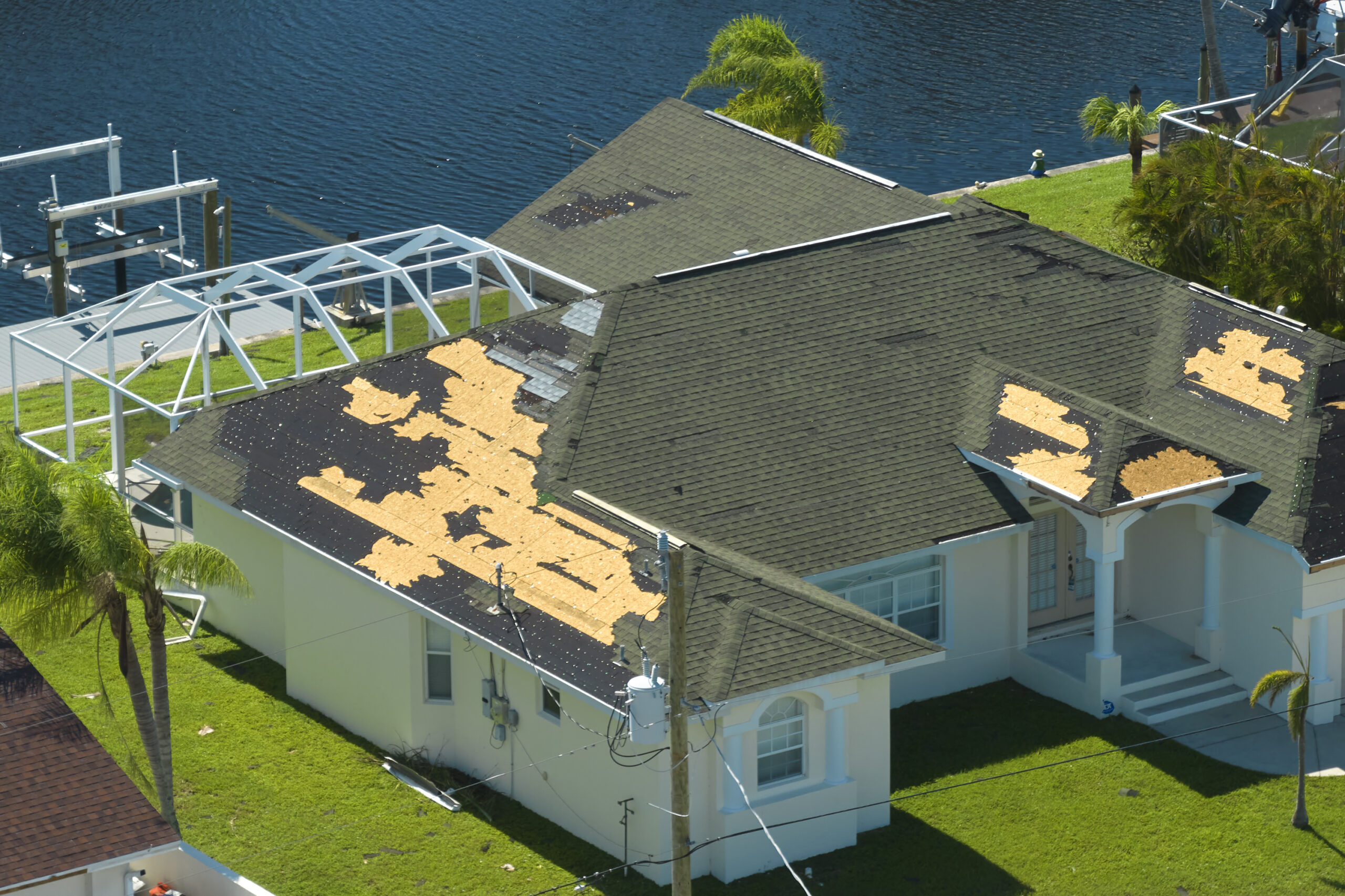 Damaged house roof with missing shingles after hurricane Ian in Florida. Consequences of natural disaster.