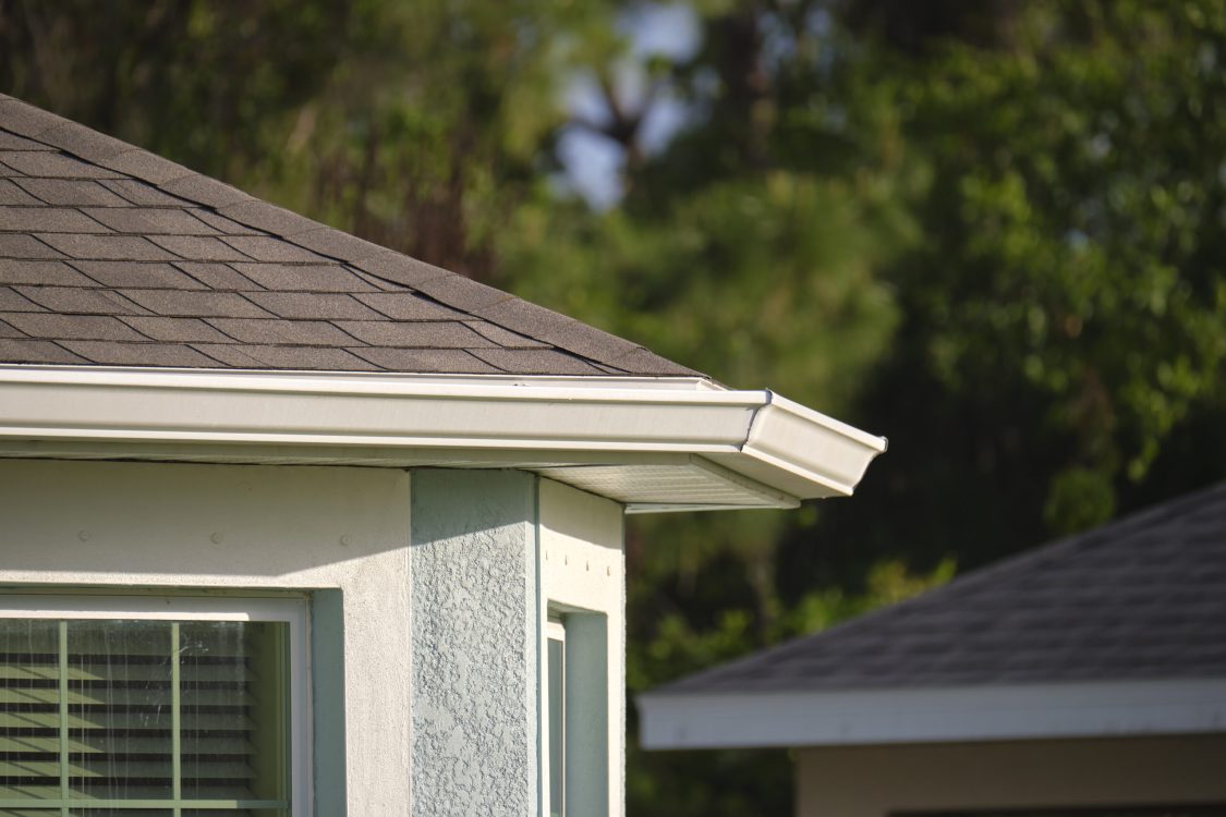 Closeup of house roof top covered with asphalt or bitumen shingles. Waterproofing of new building.